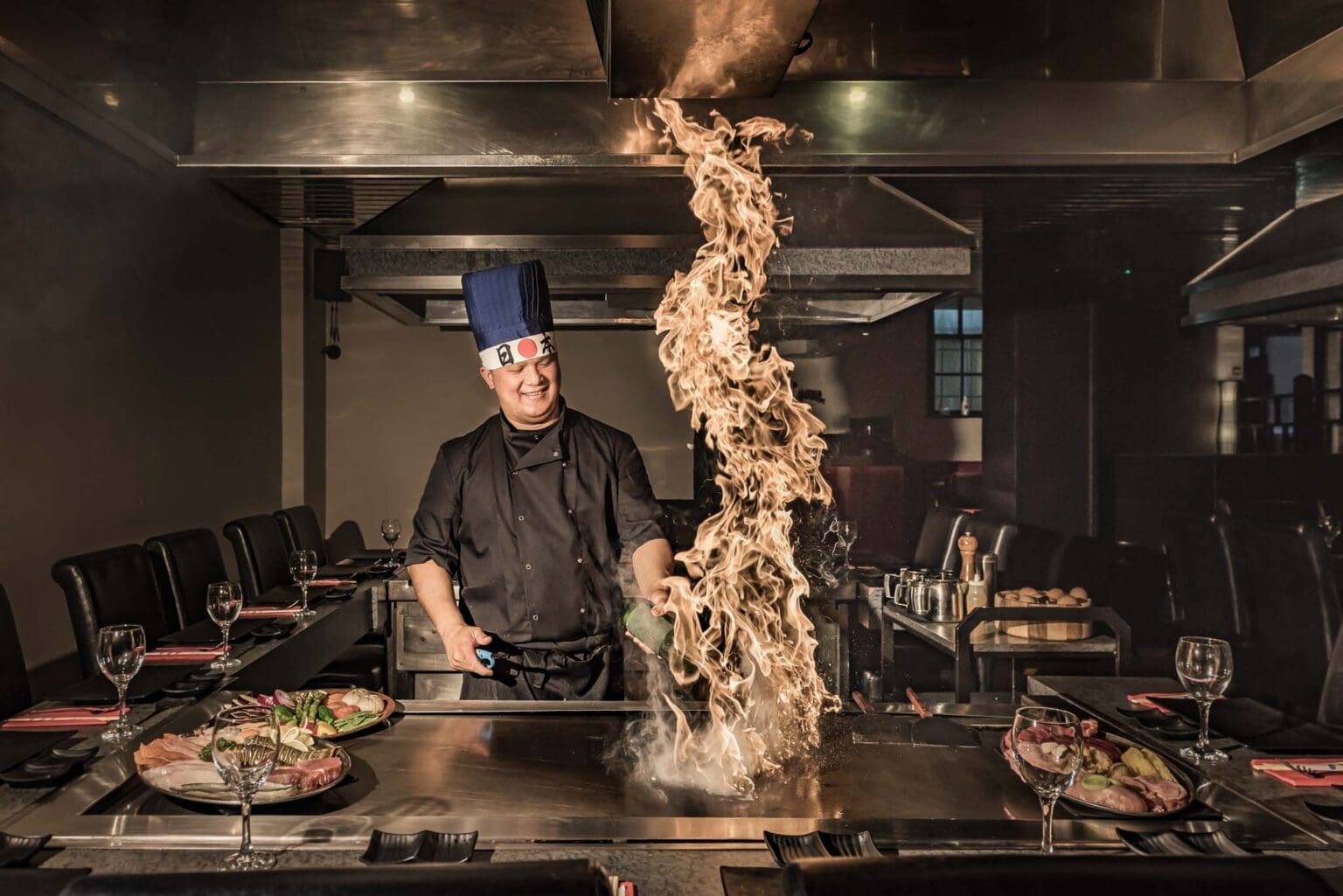 Teppanyaki chef with fire cooking