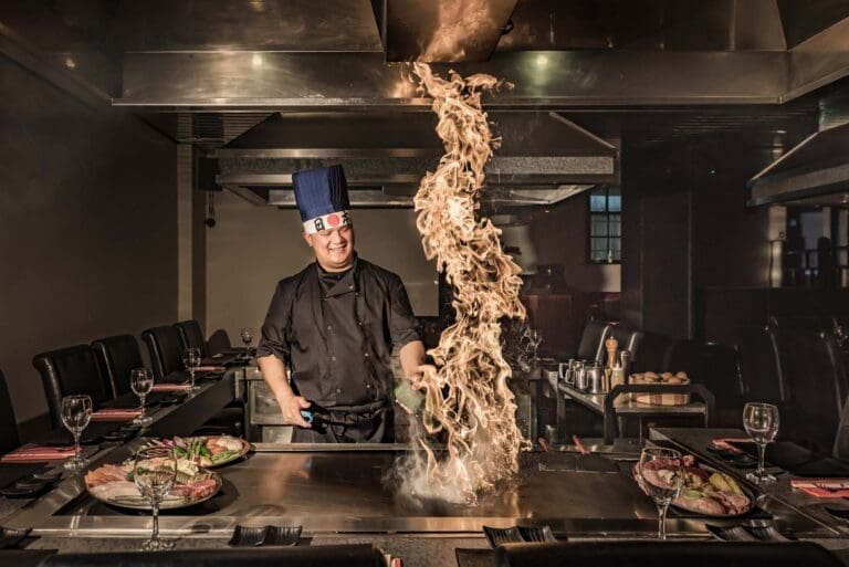 Teppanyaki chef with fire cooking